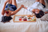 Woman smelling the rose at romantic breakfast and enjoying with her beautiful  girlfriend