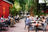 Des personnes assises tranquillement sur la terrasse verte du restaurant et bar à cocktails Alice