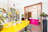 das moderne Interieur von smell stories mit einem knallgelben ovalen Tisch und einer neonpinken Theke