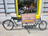 Vélo cargo propre au vélodrome avec panneau de promotion en bois