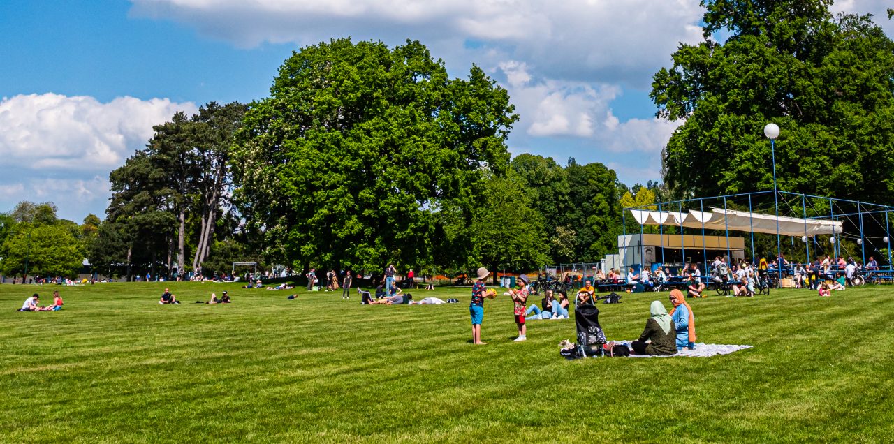 People lying on the large meadow next to Bar André in Laeken Park